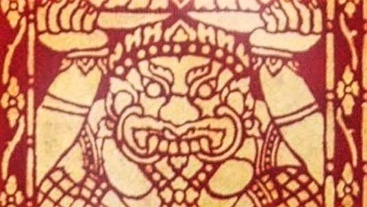 Traditional Lao painting in red and gold of a fanged, crowned giant's face