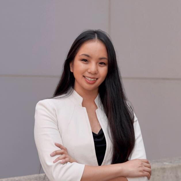 Poet Do Nguyen Mai smiling with arms crossed, wearing a white jacket