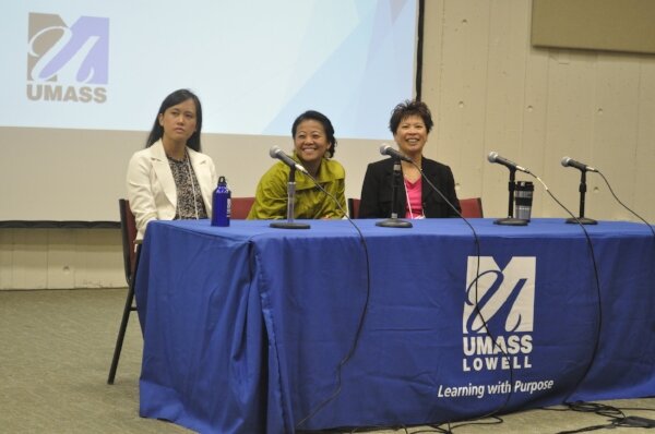 Three women seated at a UMass Lowell panel table with microphones.