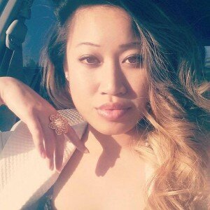 Selfie of a woman with long ombre hair in sunlight, wearing a flower ring