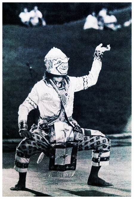 Vintage black and white photo of a masked Hanuman dancer performing outdoors in Phra Lak Phra Lam costume