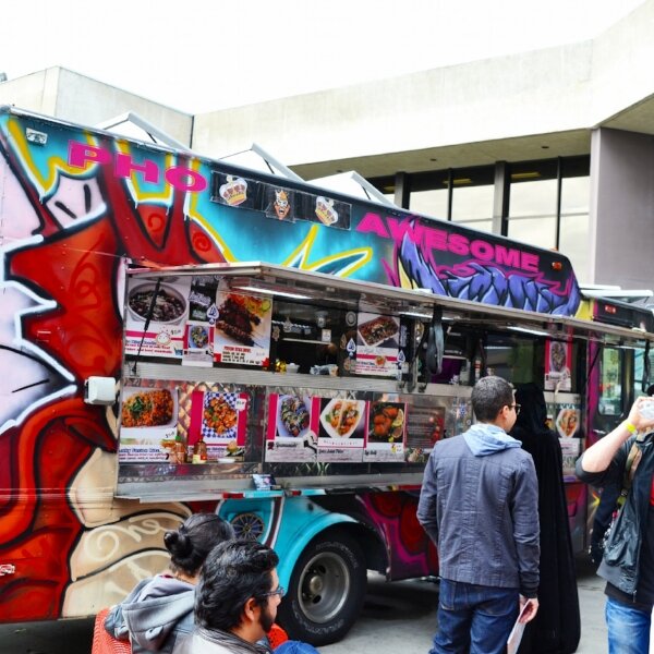 Customers line up at the brightly painted Pho Awesome food truck