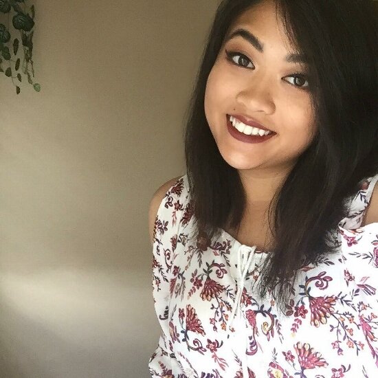 Smiling portrait of intern Savannah Rattanavong in a floral off-shoulder top.
