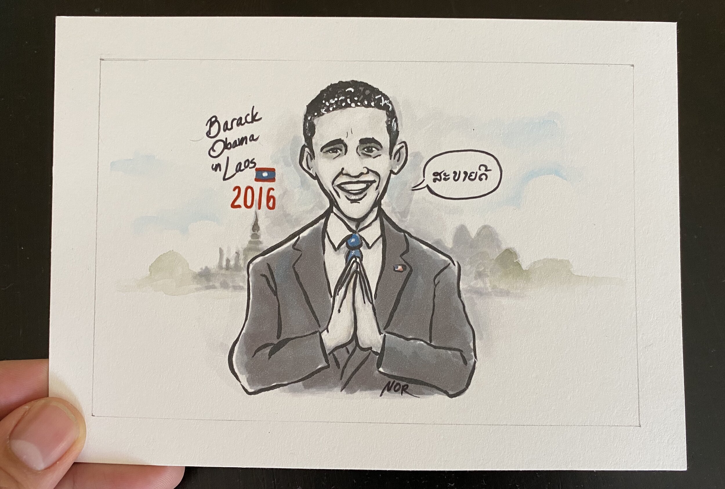Watercolor and ink card "Sabaidee" by Nor Sanavongsay: President Obama greeting with a nop, labeled "Barack Obama in Laos 2016"