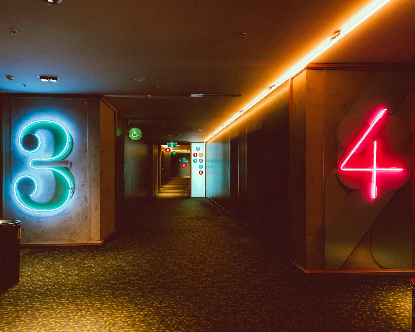 Dim hallway with a glowing teal neon number 3 and red neon number 4 on the walls.