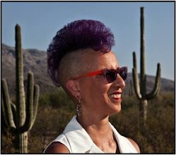 Linda D. Addison with a purple mohawk and red sunglasses, smiling in a desert with saguaro cacti
