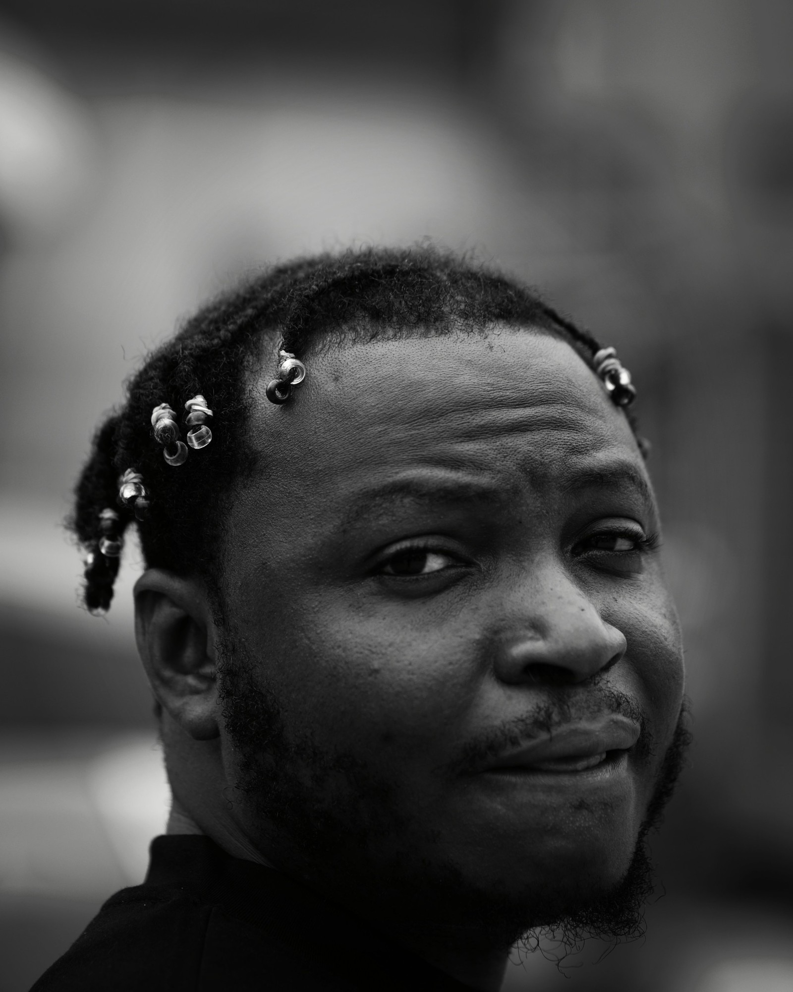 Black and white close-up portrait of Hannu Afere glancing over his shoulder