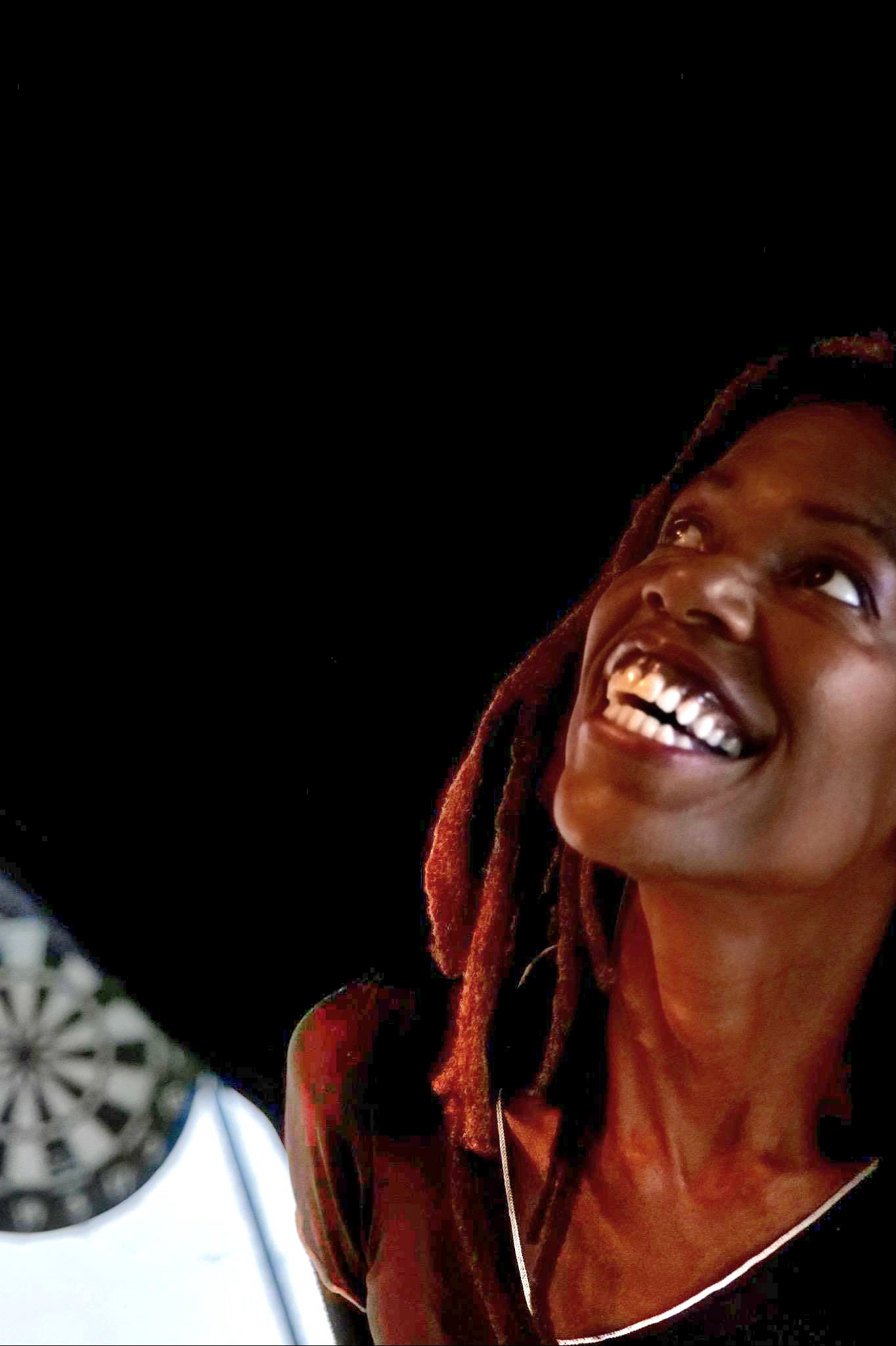 Lisa Teasley looking upward and laughing in warm, low light